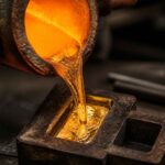 Strumień rozgrzanego metalu wlewany z tygla do metalowej formy odlewniczej