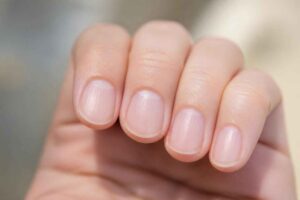 Zbliżenie dłoni z krótkimi, naturalnymi i zadbanymi paznokciami
